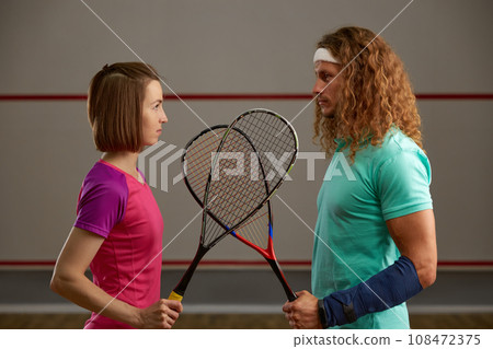 Male and female squash player confrontation on court concept 108472375