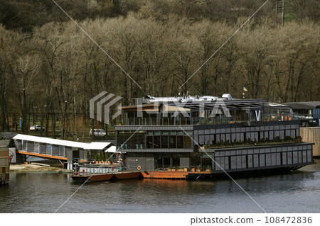 Kiev, Ukraine March 13, 2020: Restaurants floating on the water moored to the shore. Kiev, Ukraine March 13, 2020: Restaurants floating on the water moored to the shore. 108472836