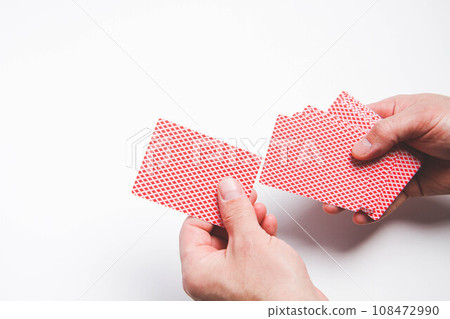 A deck of playing cards in hand. The player deals cards. Poker game. A deck of playing cards in hand. The player deals cards. Poker game. 108472990