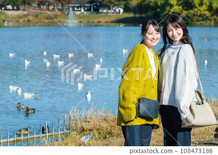 Young woman standing by the water in the park 108473186
