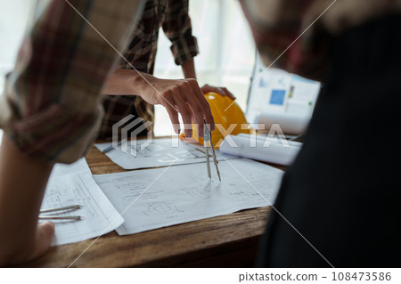 Engineers, designers and interior designers are finalizing the design of interiors by discussing selecting materials and colors to design rooms to present to clients 108473586