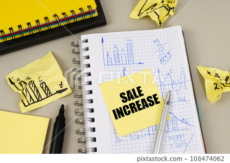 On the table there is a notepad with notes and sticky notes with the inscription - SALE INCREASE 108474062