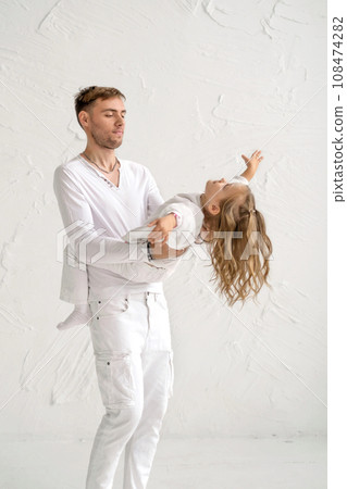 Dad is spinning merrily with his daughter in his arms. The girl spread her arms to the sides, spinning with her father Dad is spinning merrily with his daughter in his arms. The girl spread her arms to the sides, spinning with her father 108474282