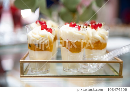 Dessert in glasses with layers of whipped cream and golden fruit compote 108474306