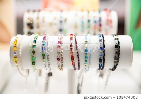 Colorful gemstone bracelets on a white stand with a blurred background Colorful gemstone bracelets on a white stand with a blurred background 108474308