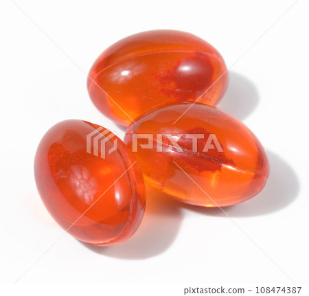 Orange capsules with fish oil on a white background, top view Orange capsules with fish oil on a white background, top view 108474387