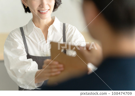 Female cafe staff serving customers Female cafe staff serving customers 108474709