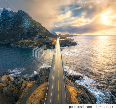 Aerial view of bridge, sea with waves and mountains at sunset Aerial view of bridge, sea with waves and mountains at sunset 108474943