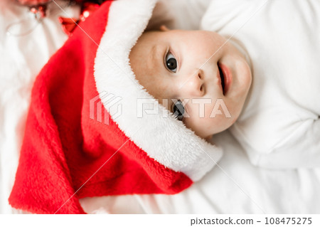 Beautiful little baby portrait celebrates Christmas. New Year's holidays. Baby in a Christmas costume with gift 108475275