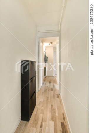 a long hallway with wood flooring and white walls in the room is very clean, but it's hard to see how a long hallway with wood flooring and white walls in the room is very clean, but it's hard to see how 108475880