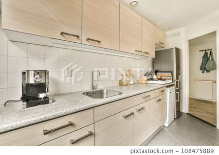 a kitchen area with white cabinets and counter space for the sink, coffee maker and toaster on the wall 108475889