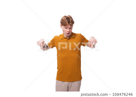 young caucasian man with red hair is dressed in a yellow t-shirt on a studio background young caucasian man with red hair is dressed in a yellow t-shirt on a studio background 108476246