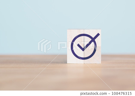Wooden cube block with checkmark icon on wood table. Goals achievement and business success. Quality and ISO symbol. Do the right thing. Tick and cross signs, approve and disapprove symbol. Wooden cube block with checkmark icon on wood table. Goals achievement and business success. Quality and ISO symbol. Do the right thing. Tick and cross signs, approve and disapprove symbol. 108476315