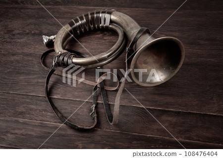 Hunting horn on rustic wood plank. 108476404