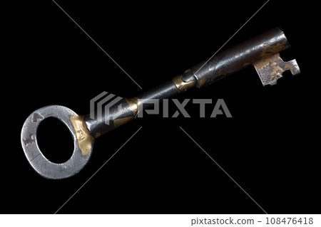 Old rusty key on a black. 108476418