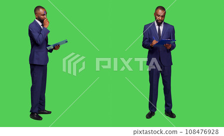 Startup manager thinking about new information on camera, brainstorming ideas and taking notes on clipboard files. Corporate employee wearing business suit and being thoughtful. 108476928