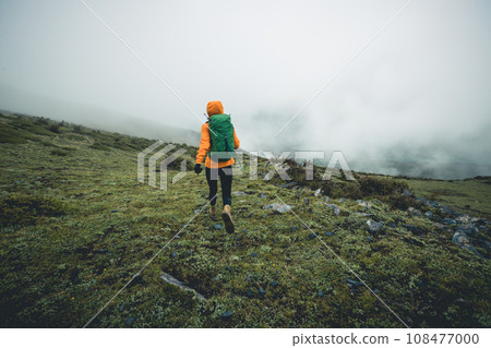 Hiking woman on high altitude mountain top 108477000