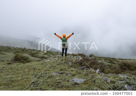 Hiking woman on high altitude mountain top 108477001