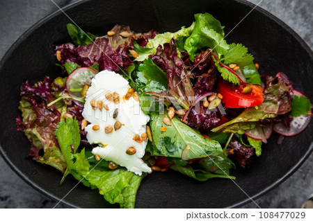 salad with lettuce, radishes, tomatoes, parsley, seeds and cheese side view salad with lettuce, radishes, tomatoes, parsley, seeds and cheese side view 108477029