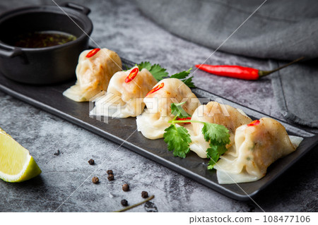 steamed dumplings with herbs, chili and soy sauce steamed dumplings with herbs, chili and soy sauce 108477106