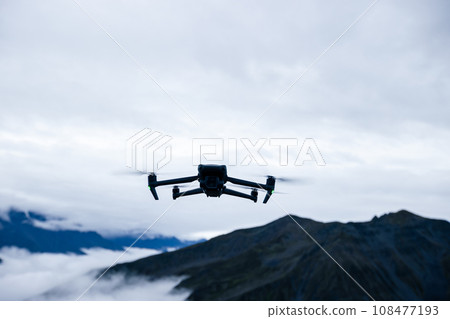 Flying drone in high altitude mountains Flying drone in high altitude mountains 108477193