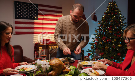 Man preparing and serving roasted turkey for thanksgiving 108477806