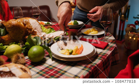Man preparing and serving roasted turkey for thanksgiving 108477818