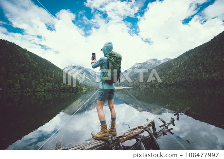 Woman walking on a one plank bridge in high altitude mountains 108477997