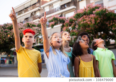 Curious preteen children pointing at something while walking outdoors 108479000