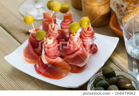 Traditional Spanish tapas - rolls of ham served with green olives Traditional Spanish tapas - rolls of ham served with green olives 108479062