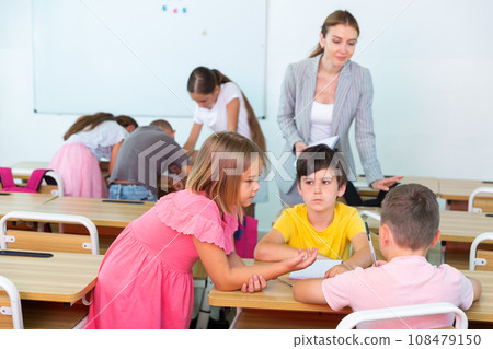 Interested preteen pupils discussing learning material in groups Interested preteen pupils discussing learning material in groups 108479150