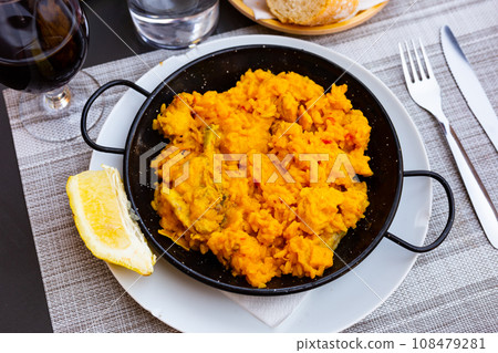 Valencian seafood paella - savory rice dish with shrimps, clams and chicken 108479281