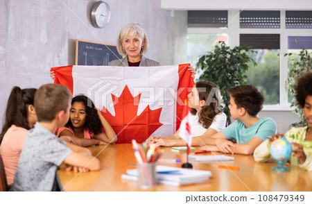 students listen to woman teacher who talks about Canada students listen to woman teacher who talks about Canada 108479349