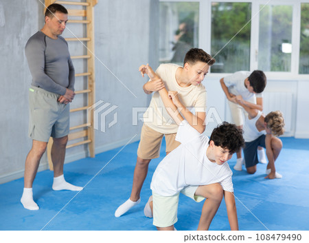 Teen boys practicing armlock in training bout during self defence course 108479490