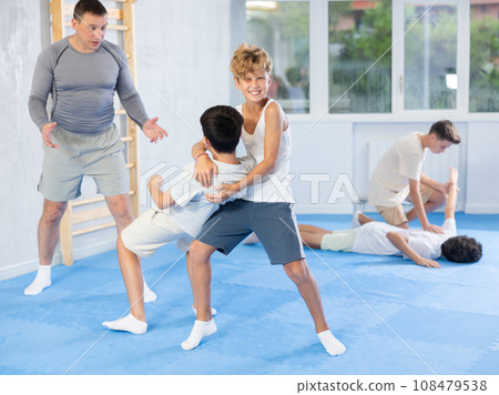 Teenagers practicing inverted facelock self-defense technique in training bout Teenagers practicing inverted facelock self-defense technique in training bout 108479538