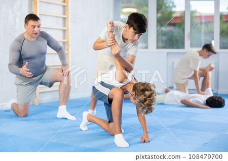 Teenagers practicing armlock in training sparring at self-defense classes 108479700