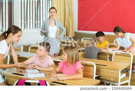 Preteen schoolchilds working in groups at lesson 108480064