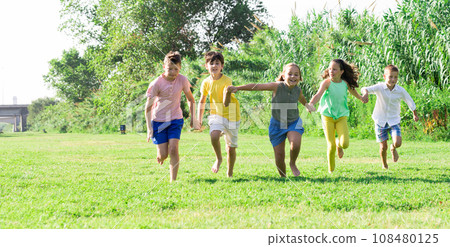 Barefoot kids running on green grass 108480125