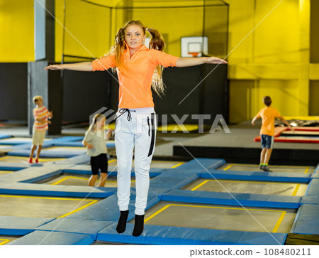 Girl jumping on trampoline park in sport center 108480211