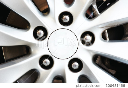 Close up of a gray car wheel hub cap with chrome wheel nuts in the car wheel , Car parts concept Close up of a gray car wheel hub cap with chrome wheel nuts in the car wheel , Car parts concept 108481466