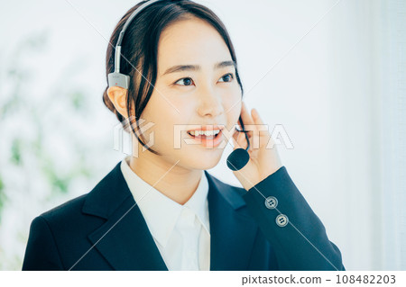 A woman in a suit wearing a headset A woman in a suit wearing a headset 108482203