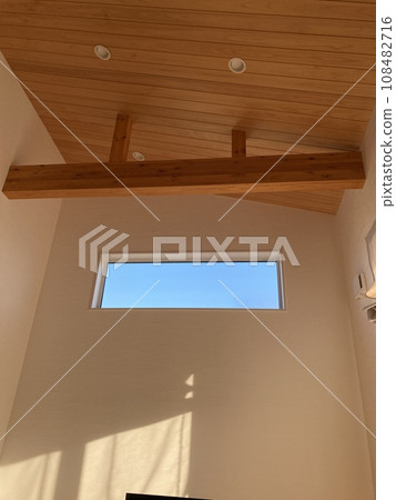 Living room with sloped ceiling and light windows Living room with sloped ceiling and light windows 108482716