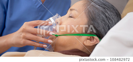 Nurse putting oxygen mask with patient elderly woman on bed for diagnose and healing in hospital. 108482972