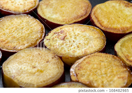 Grilled sweet potato with butter and soy sauce, cooking scene. 108482985