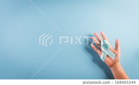 World diabetes day awareness concept. Hand holding blue ribbon, symbolic bow color raising awareness in diabetes day on pastel background,  14 November. 108483244
