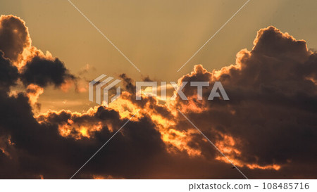Beautiful dramatic sky with clouds at sunset or sunrise. Sunset sky at dusk in the evening with natural sky background with golden orange clouds. Beautiful dramatic sky with clouds at sunset or sunrise. Sunset sky at dusk in the evening with natural sky background with golden orange clouds. 108485716