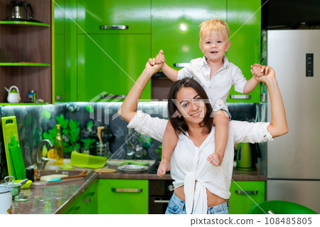 happy family, mother holding her son in her arms in the kitchen 108485805