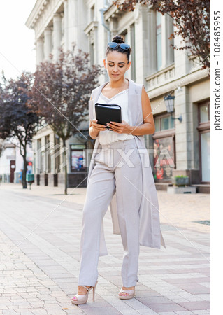 Successful businessman or entrepreneur smiling holding notepad while walking Successful businessman or entrepreneur smiling holding notepad while walking 108485955