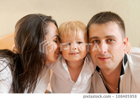 happy family lying on the bed and hugging, mom dad and little son happy family lying on the bed and hugging, mom dad and little son 108485958