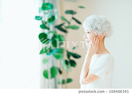 A senior woman feels that her skin is moisturized. 108486391